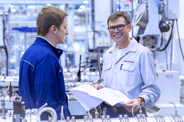 Two employees talk to each other in the machine hall