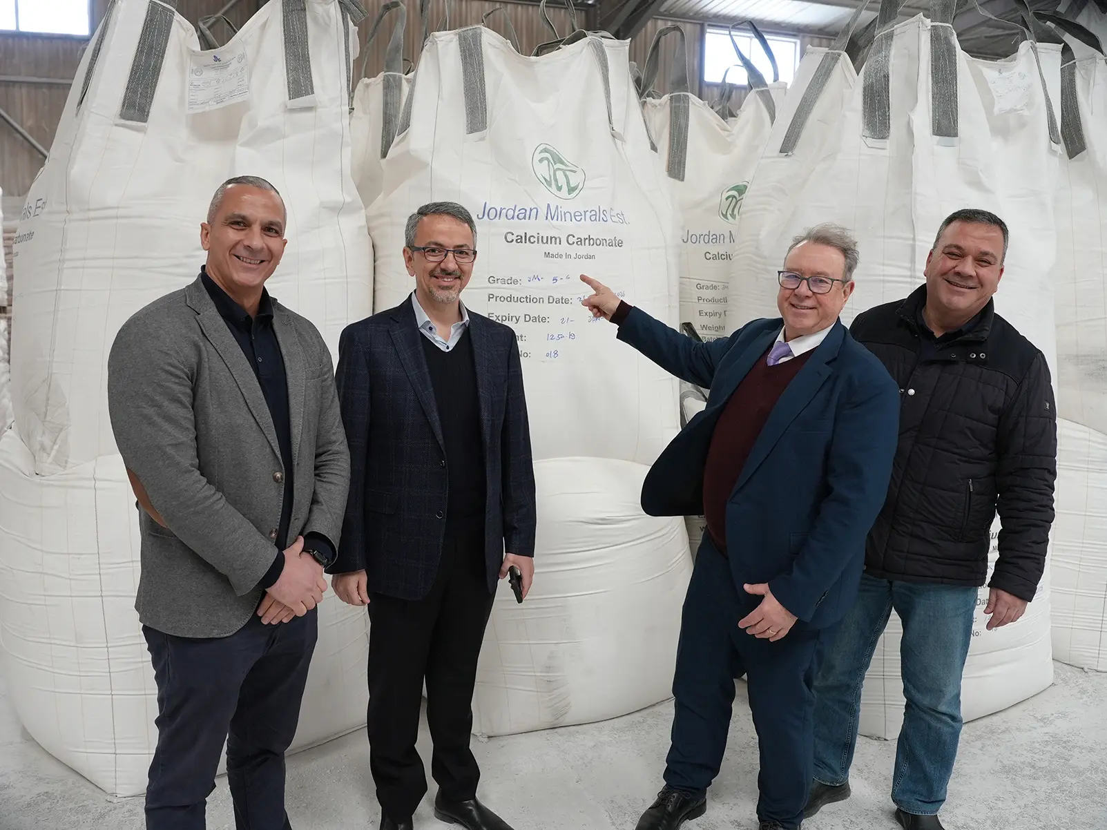 Dietmar Alber von Hosokawa Alpine mit drei Kollegen von Jordan Minerals vor Säcken mit GCC