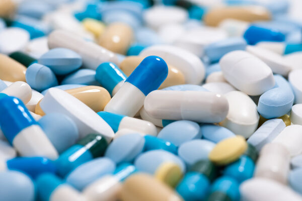 Colorful tablets and capsules, mainly in blue and white
